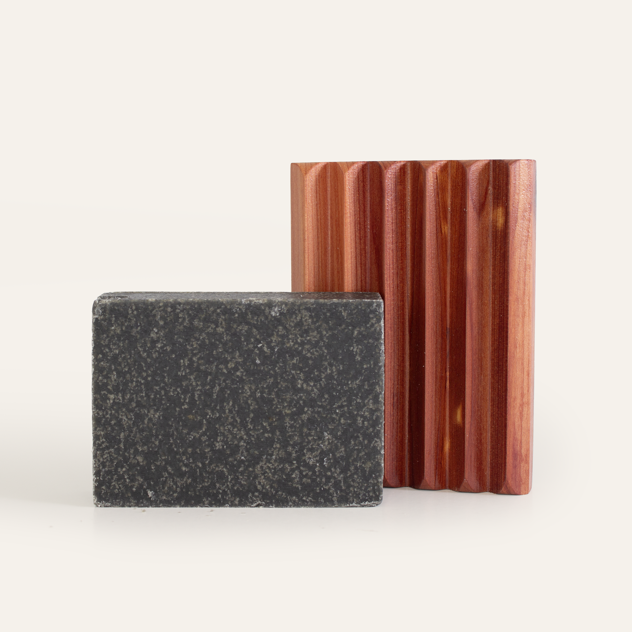 The Little Seed Farm Soap Bar + Dish Set features a black rectangular soap bar and a vertical ridged cedar dish with a natural brown finish, both displayed against a simple light background.