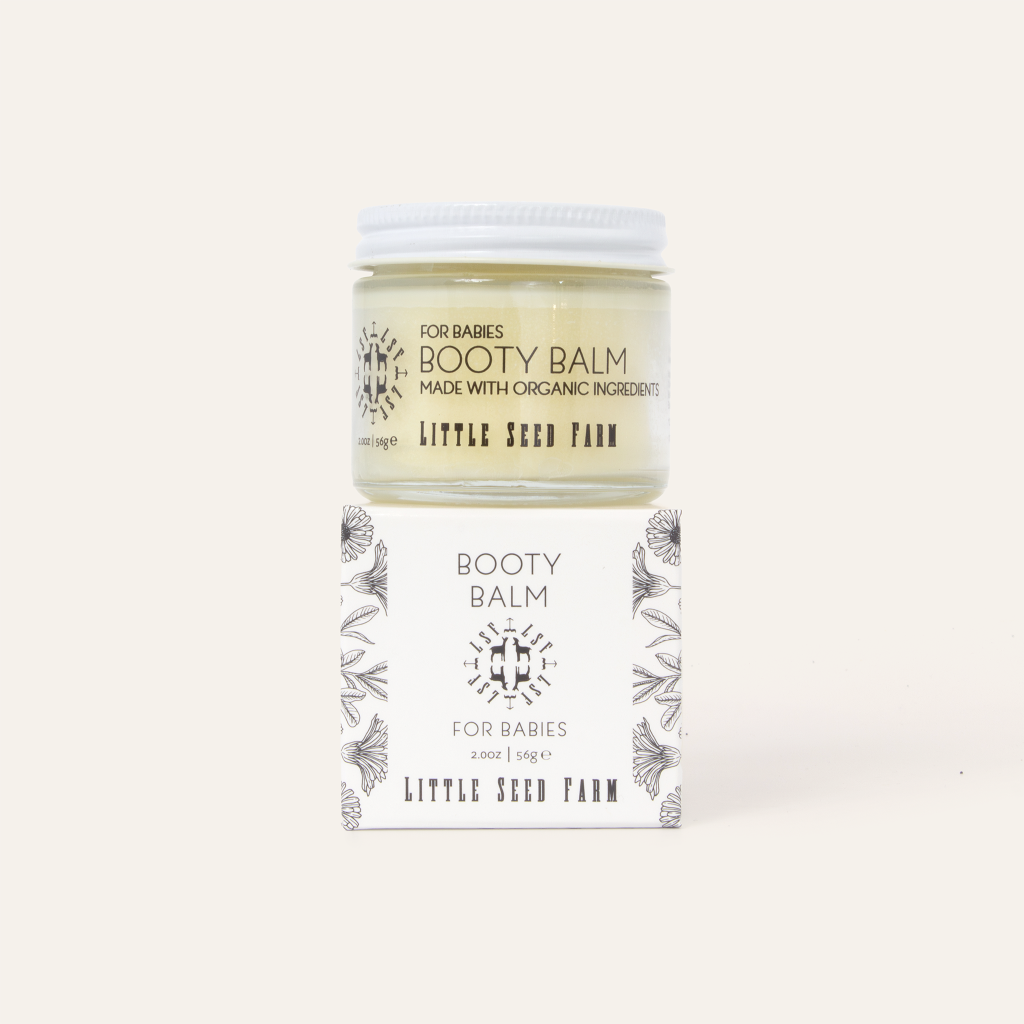 Little Seed Farm Baby Diaper Balm in a glass jar, a gentle yet potent salve made with herbally infused coconut oil, shea butter, and organic healing botanicals to soothe and protect delicate baby skin.