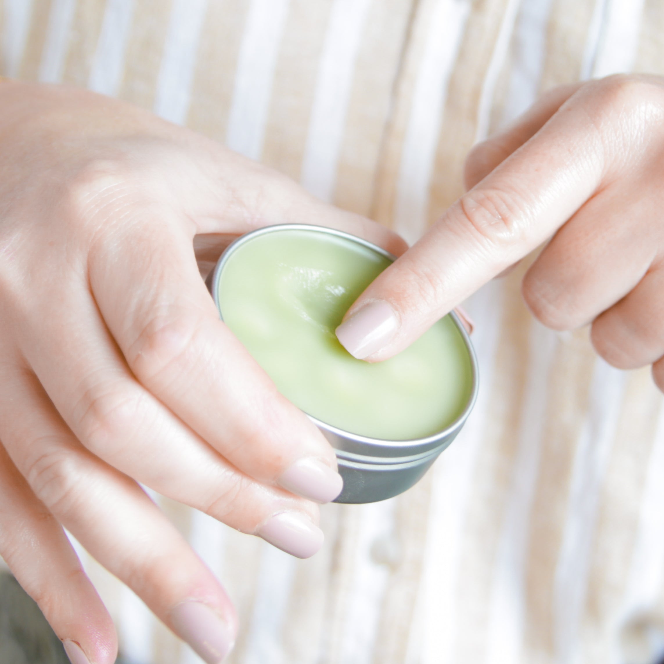 Open tin of Blue Tansy Rose Hand‑Aid Healing Hand Balm revealing its smooth, richly emollient texture made with herb-infused coconut oil and beaming with skin-healing nutrients for hardworking hands.