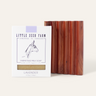 A Little Seed Farm Soap Bar + Dish Set, featuring goat milk soap with a horse illustration and a handmade cedar soap dish with vertical grooves, is displayed.