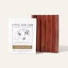 A Little Seed Farm Soap Bar + Dish Set, featuring a goat milk soap with a charming goat illustration and an artisanal cedar dish, rests on a light background.