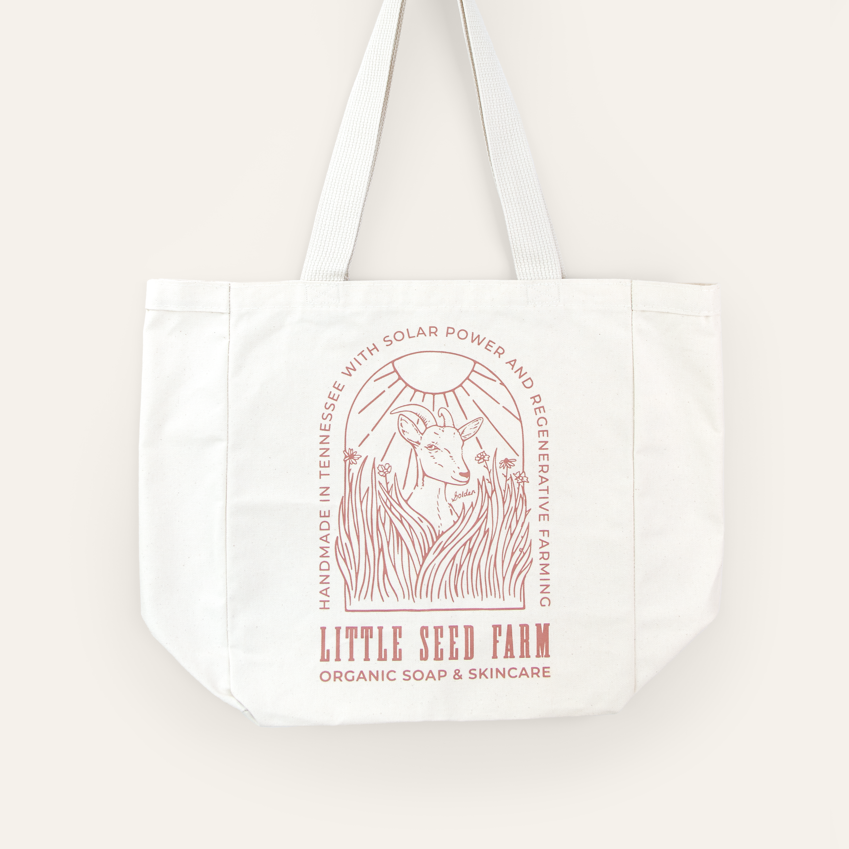 A neutral-colored tote bag featuring a minimalist goat illustration, showcasing its spacious design and sturdy handles.
