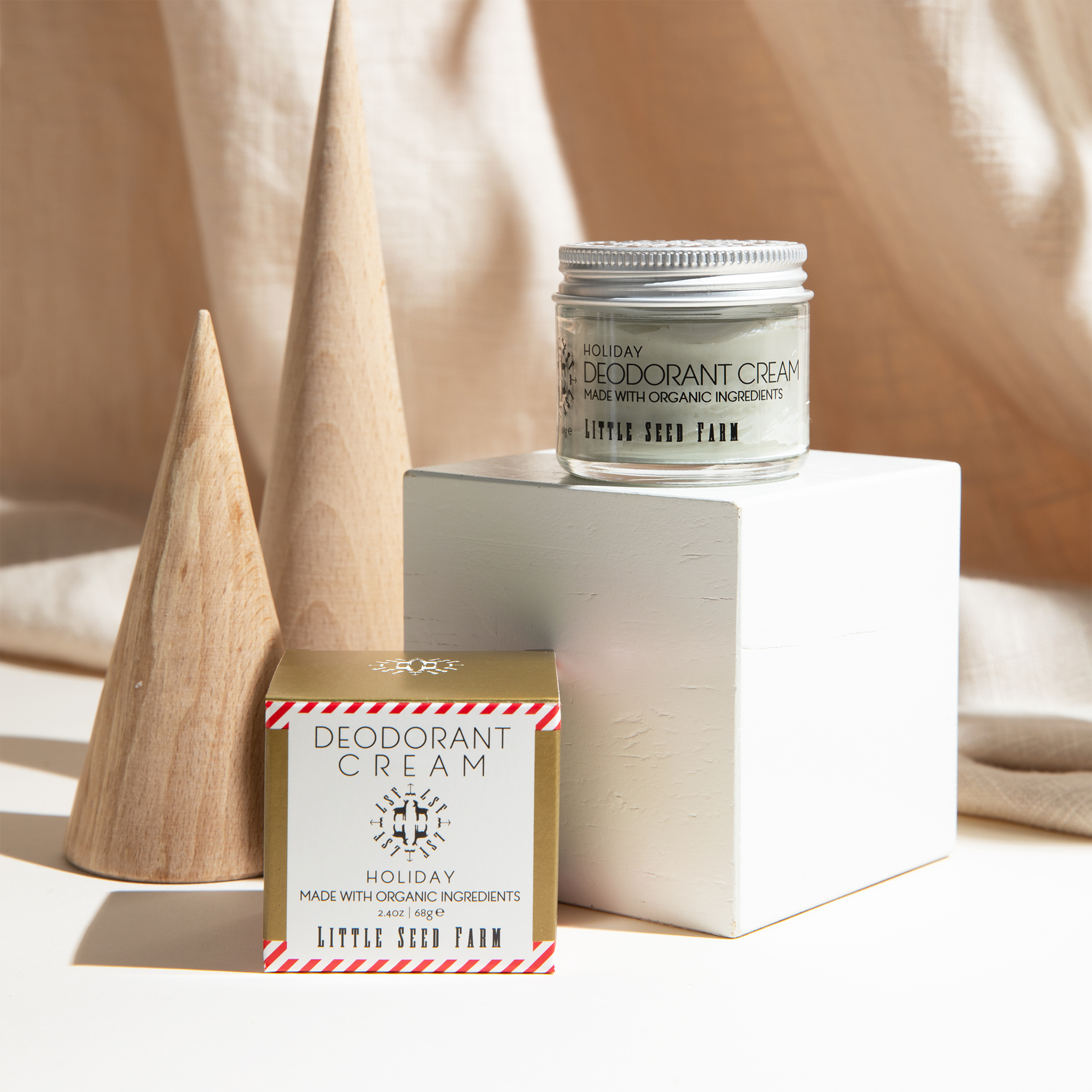 Close-up of Holiday Deodorant Cream texture inside jar, creamy light tone with fine granules showing activated charcoal blend
