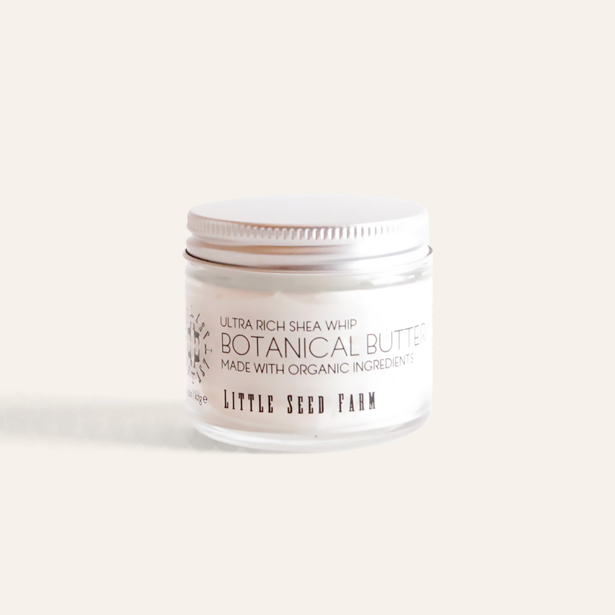 Little Seed Farm Healing Body Butter in a 1.5 oz glass jar, featuring a rich, deeply moisturizing cream made with just five organic ingredients—including shea butter, sweet almond oil, grapefruit peel oil, vanilla extract, and vitamin E—to soothe and hydrate dry or chapped skin.