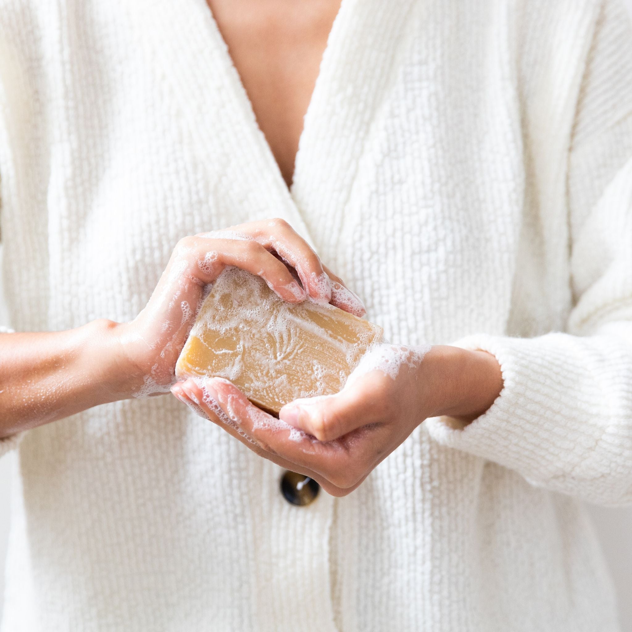 Lather from Rosemary Patchouli soap forming creamy, moisturizing foam infused with botanical rosemary and patchouli to soothe irritated skin and support cell regeneration.