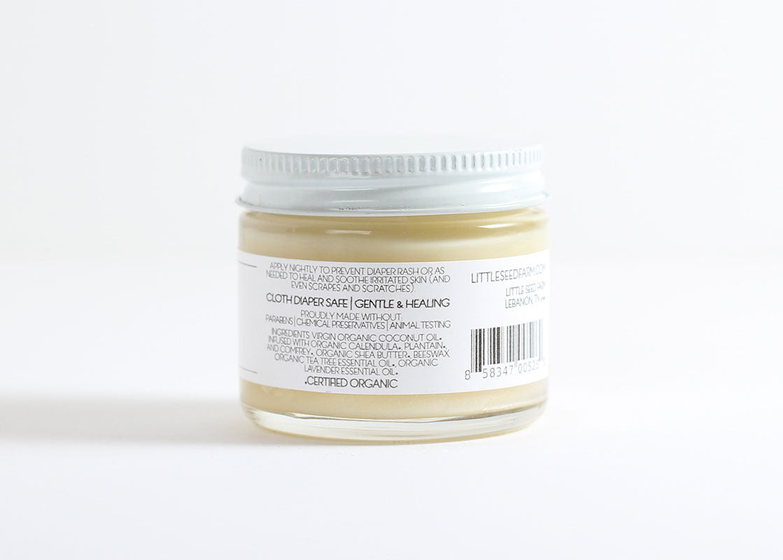 Back label of Baby Diaper Balm listing organic ingredients including herbally infused coconut oil, shea butter, beeswax, lavender and tea tree oils, vitamin E, calendula, plantain, and comfrey for soothing and healing baby skin.
