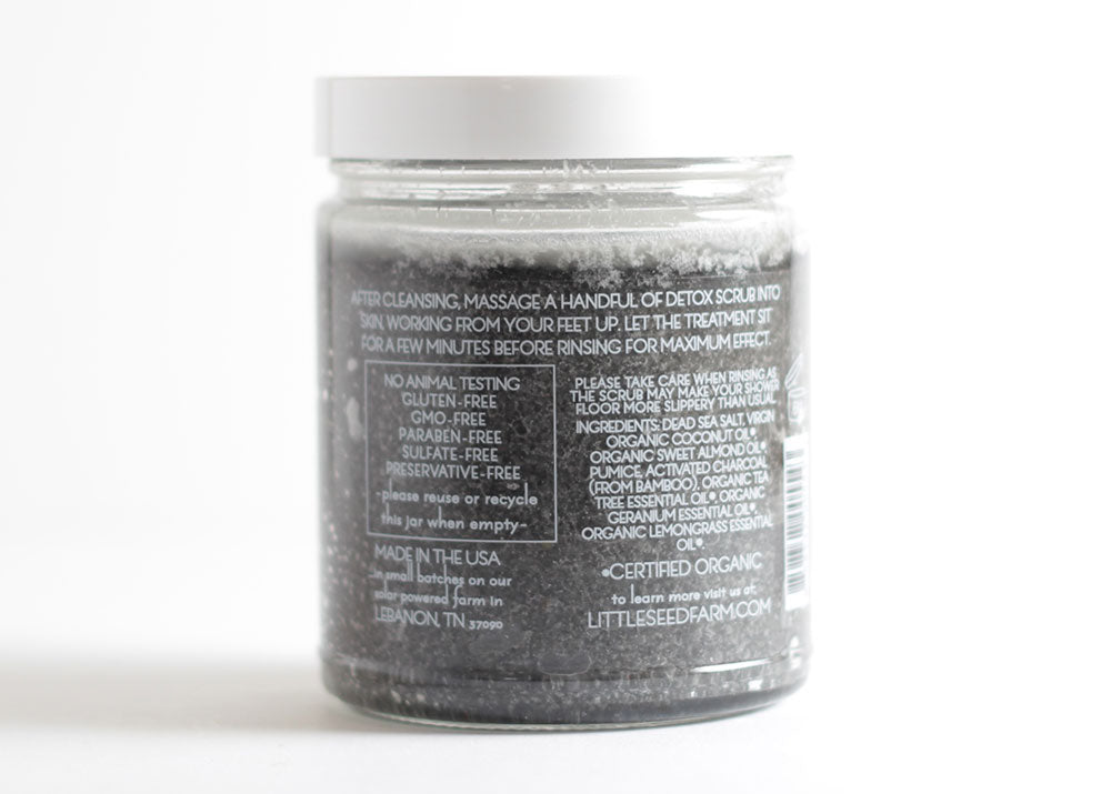 Back label showing certified organic ingredients in the Activated Charcoal Detox Scrub: Dead Sea salt, coconut and sweet almond oils, pumice, vitamin E, geranium, lemongrass, tea tree essential oils, and activated charcoal.