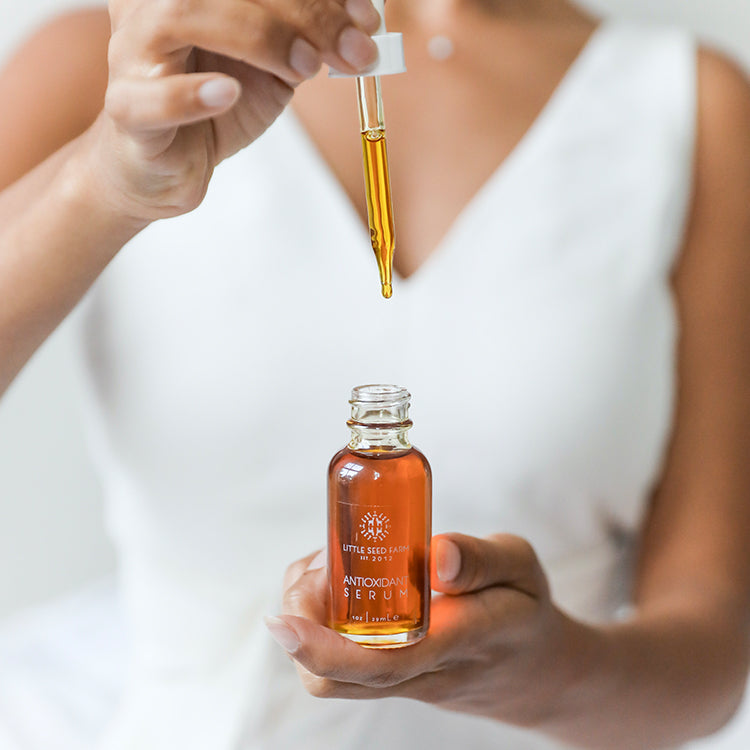 Ingredient card listing antioxidant and emollient botanicals, including organic rosehip oil, safflower seed oil infused with comfrey, calendula and plantain, sea buckthorn oil, CoQ10, vitamin E, jojoba oil, carrot seed oil, and floral essential oils.
