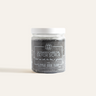 Activated Charcoal Detox Scrub in a refillable glass jar, featuring a deep-black exfoliant made with Dead Sea salt, activated charcoal, and organic coconut oil to detoxify and moisturize.